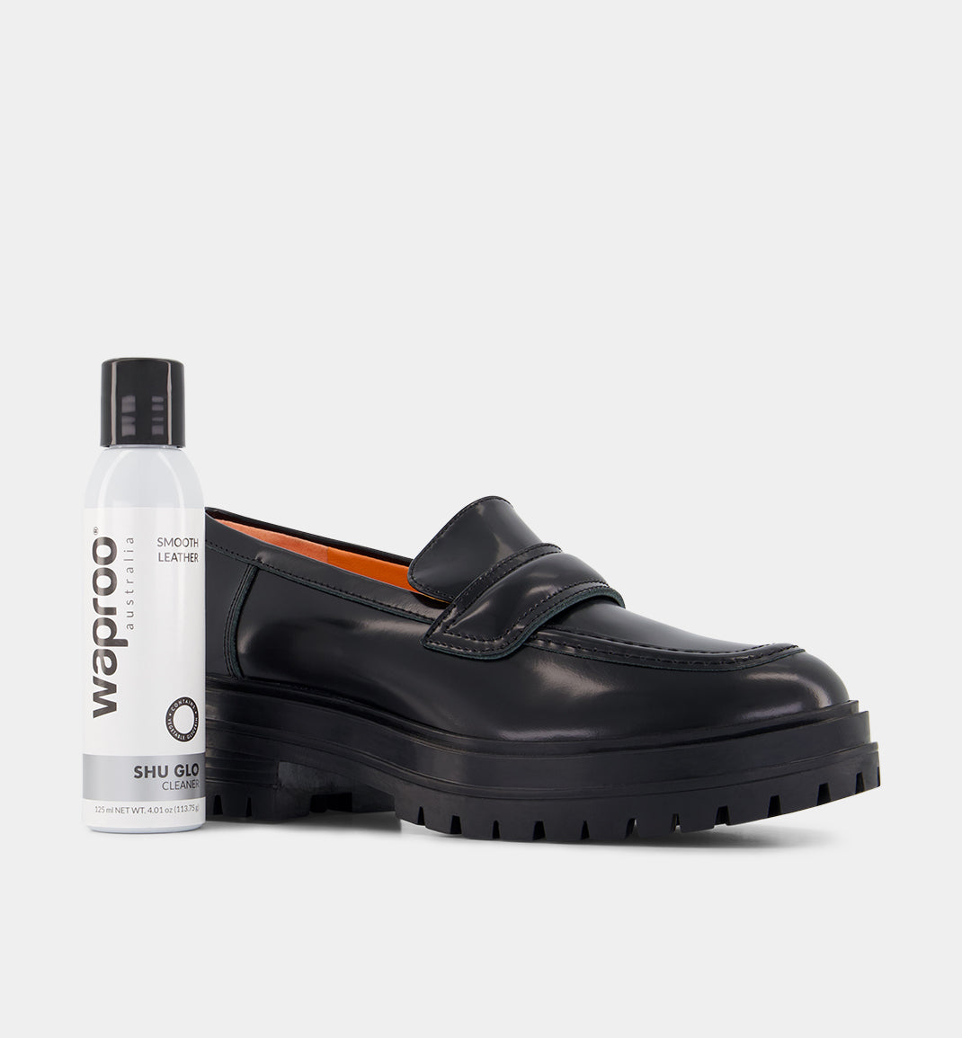A black loafer shoe next to a bottle labeled 'Waproo Platinum Shu-Glo 125ml'