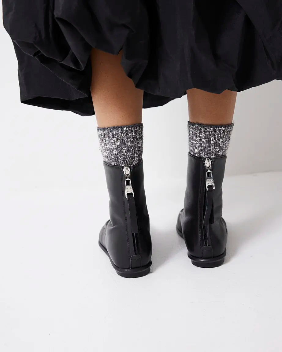 Black leather boots with back zippers on a white background