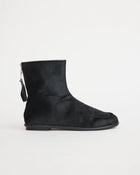 Black pony hair ankle boot with a zipper on a white background