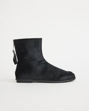 Black pony hair ankle boot with a zipper on a white background