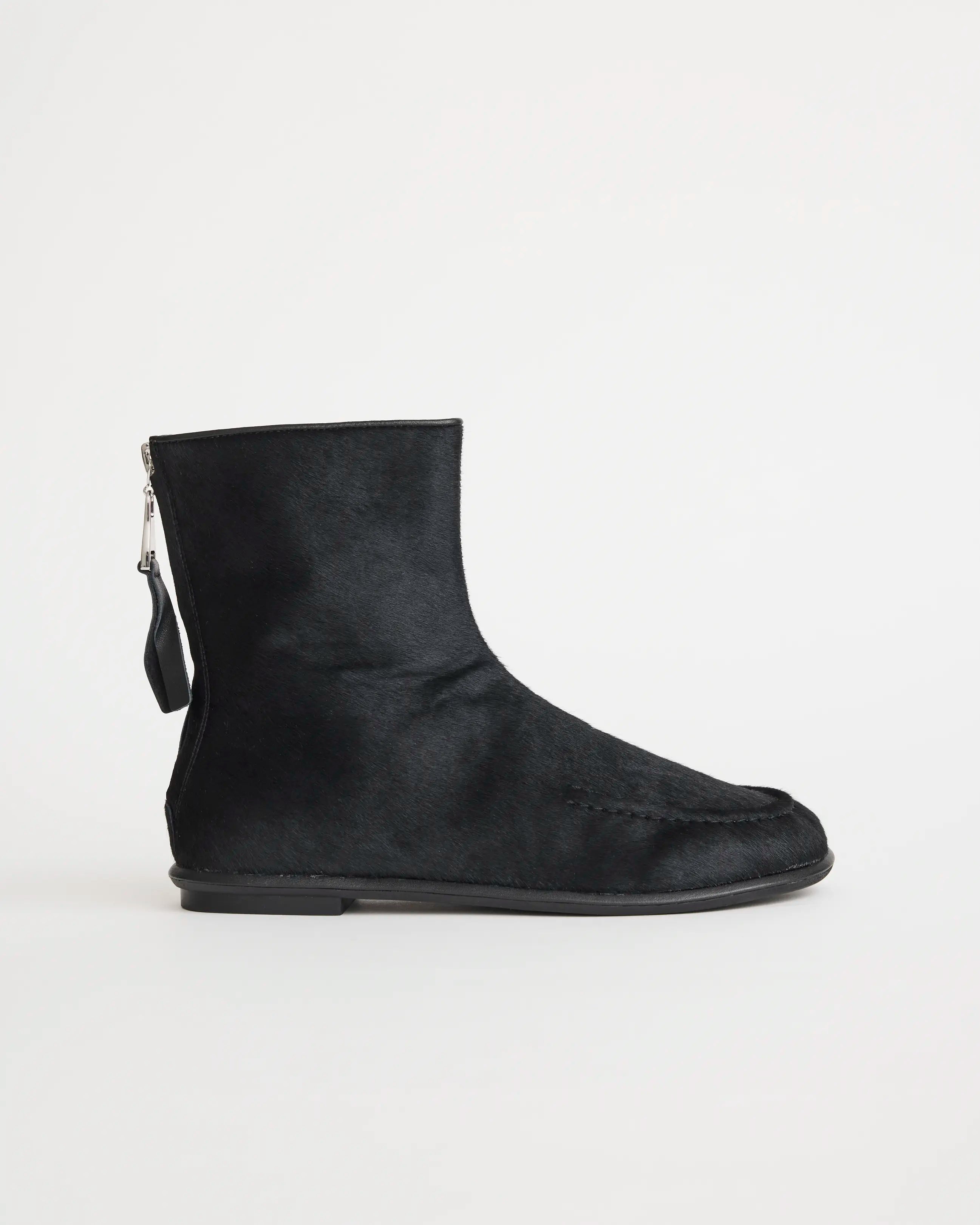 Black pony hair ankle boot with a zipper on a white background