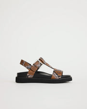 Arch support T-bar sandal with caramel snake print straps on a light gray background