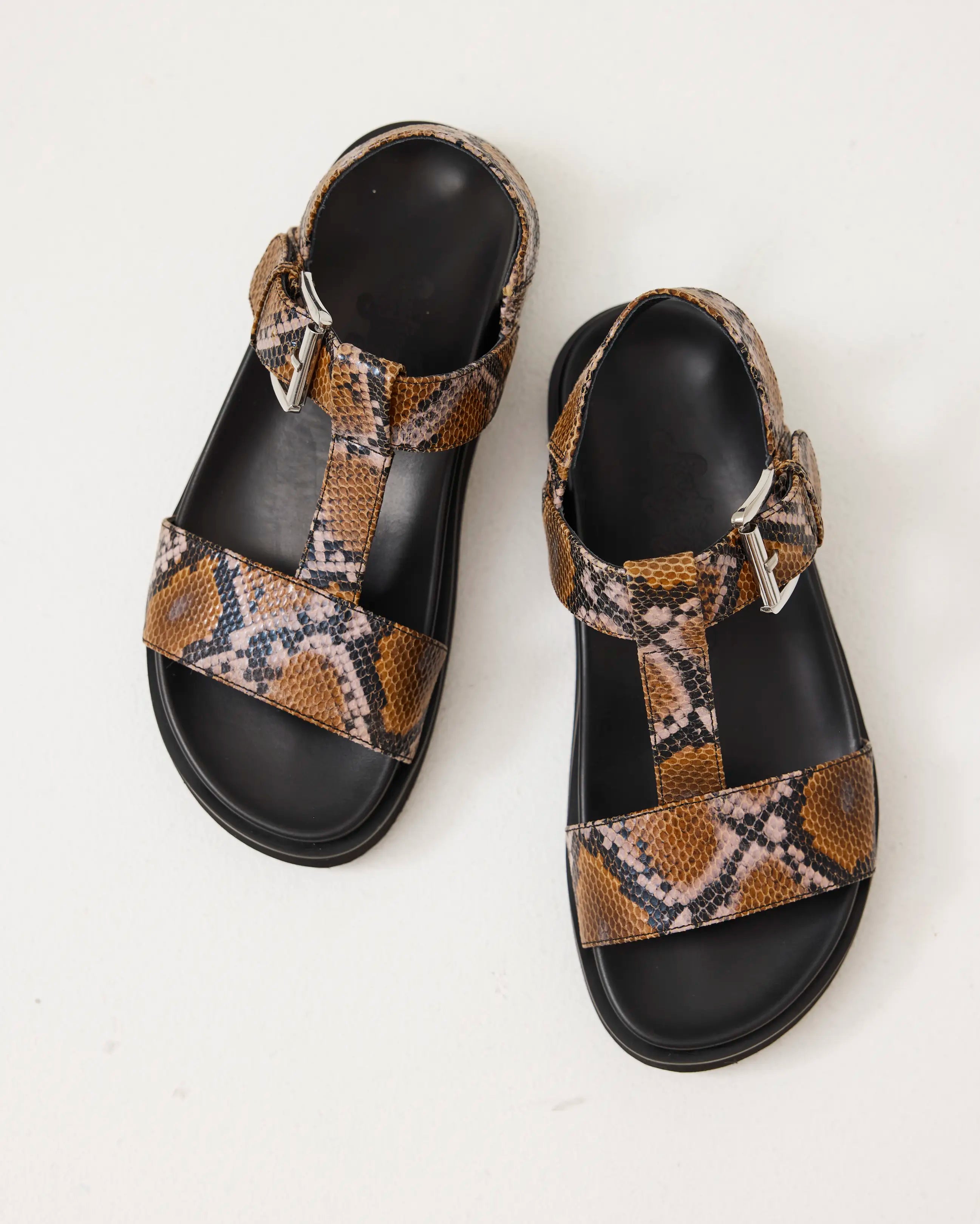 Arch support T-bar sandal with caramel snake print straps on a light gray background