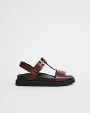A brown leather arch support T-bar sandal with a silver buckle and black sole.