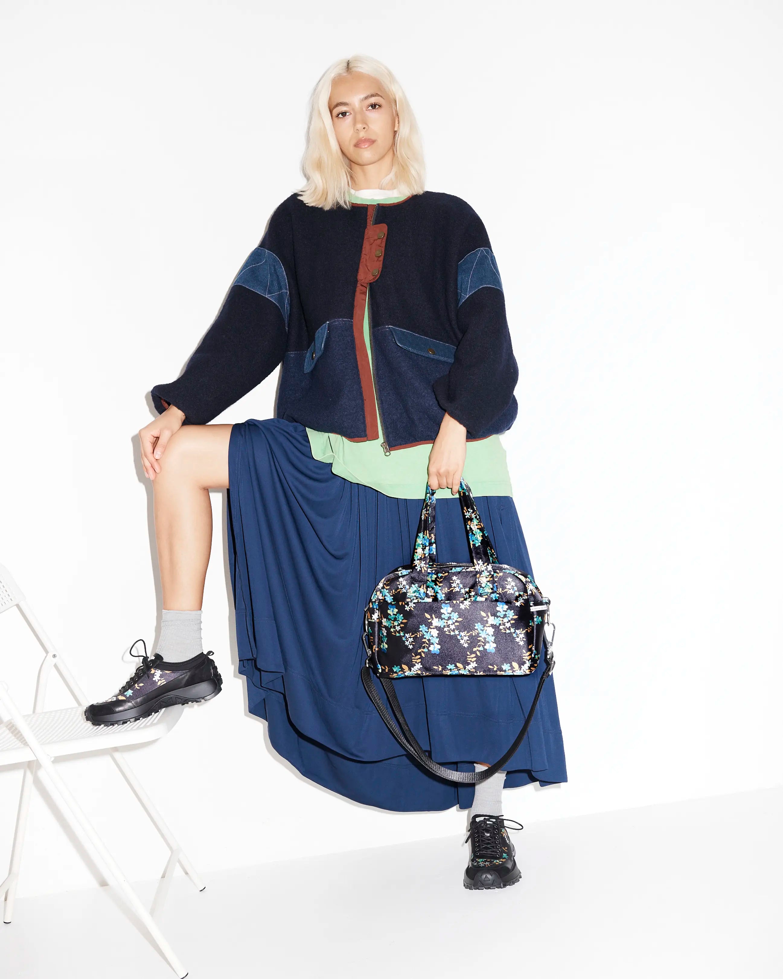 Woman holding a floral-patterned handbag with floral hikers