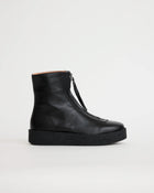 Black leather zip up ankle boot on a light gray background