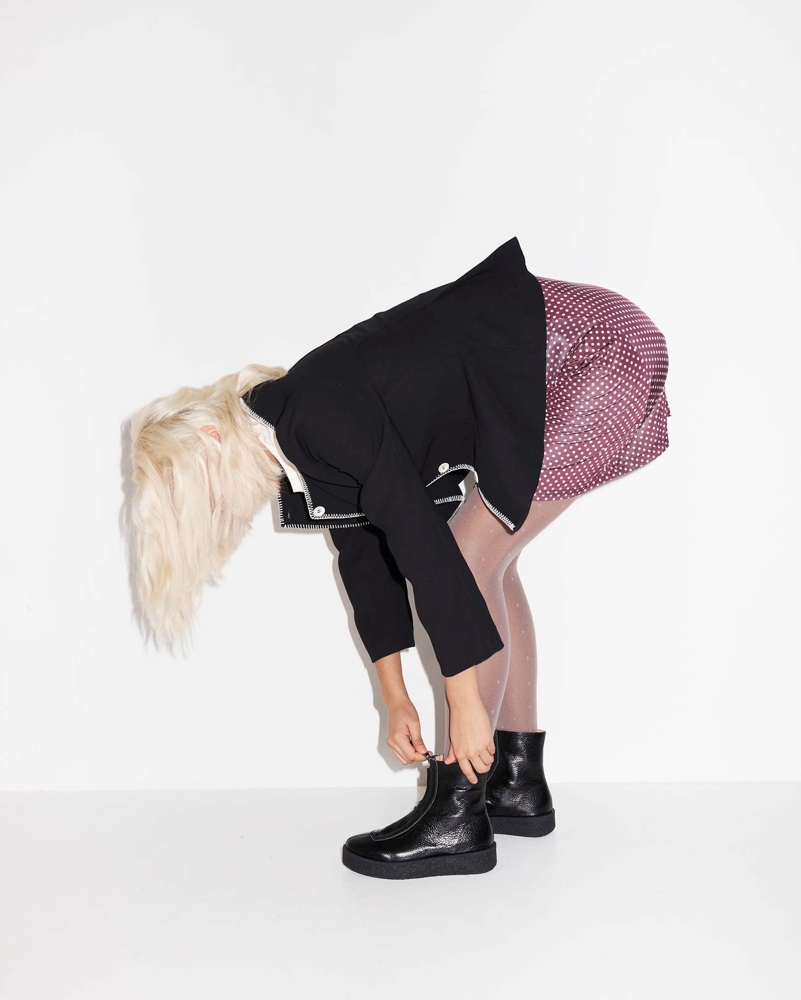 Person wearing a black coat and black ankle boots
