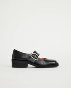 Black leather square-toe Mary Jane shoe with a buckle on a light grey background