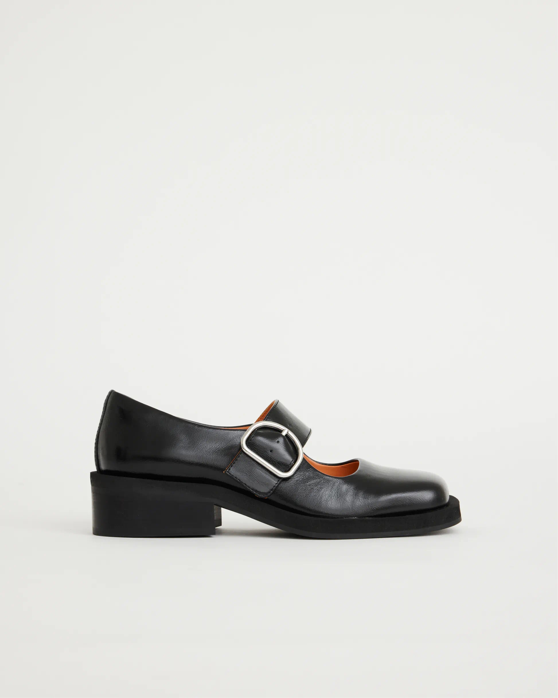 Black leather square-toe Mary Jane shoe with a buckle on a light grey background