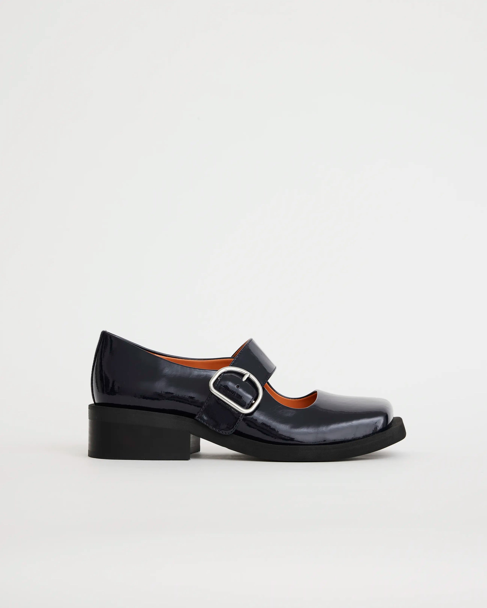 Glossy navy leather square toe shoe with silver buckle on a white background