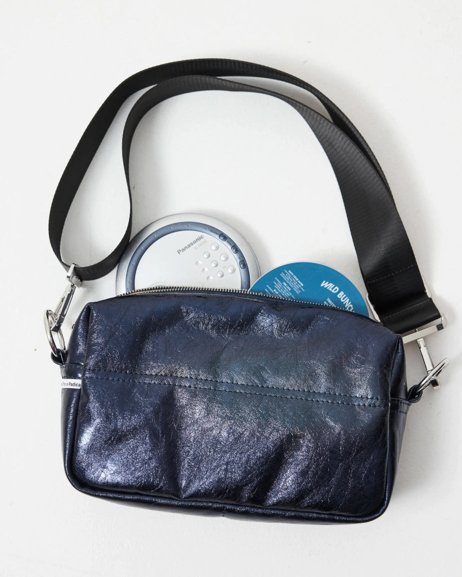 Blue leather bag with a black strap on a white background