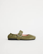 Green leather flat shoe with a silver buckle on a white background