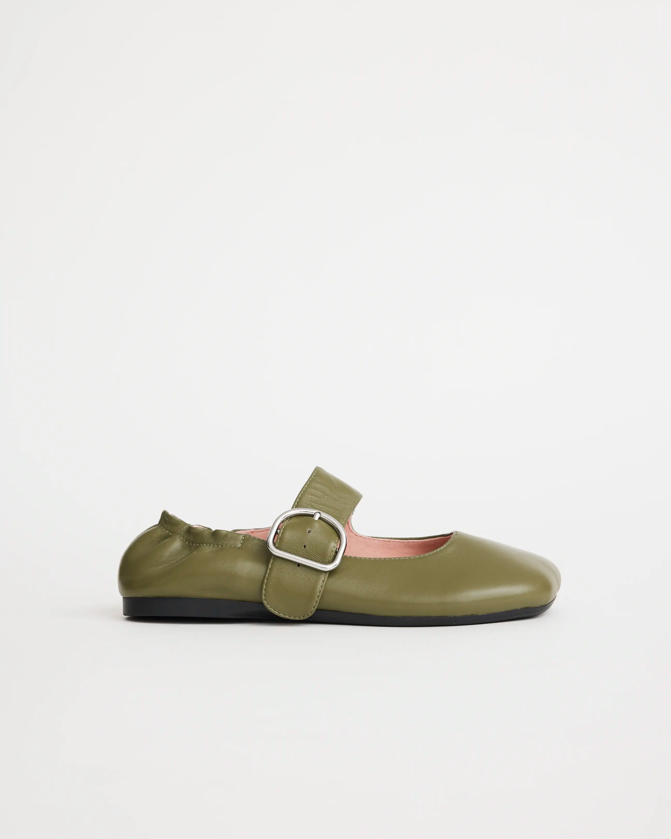 Green leather flat shoe with a silver buckle on a white background