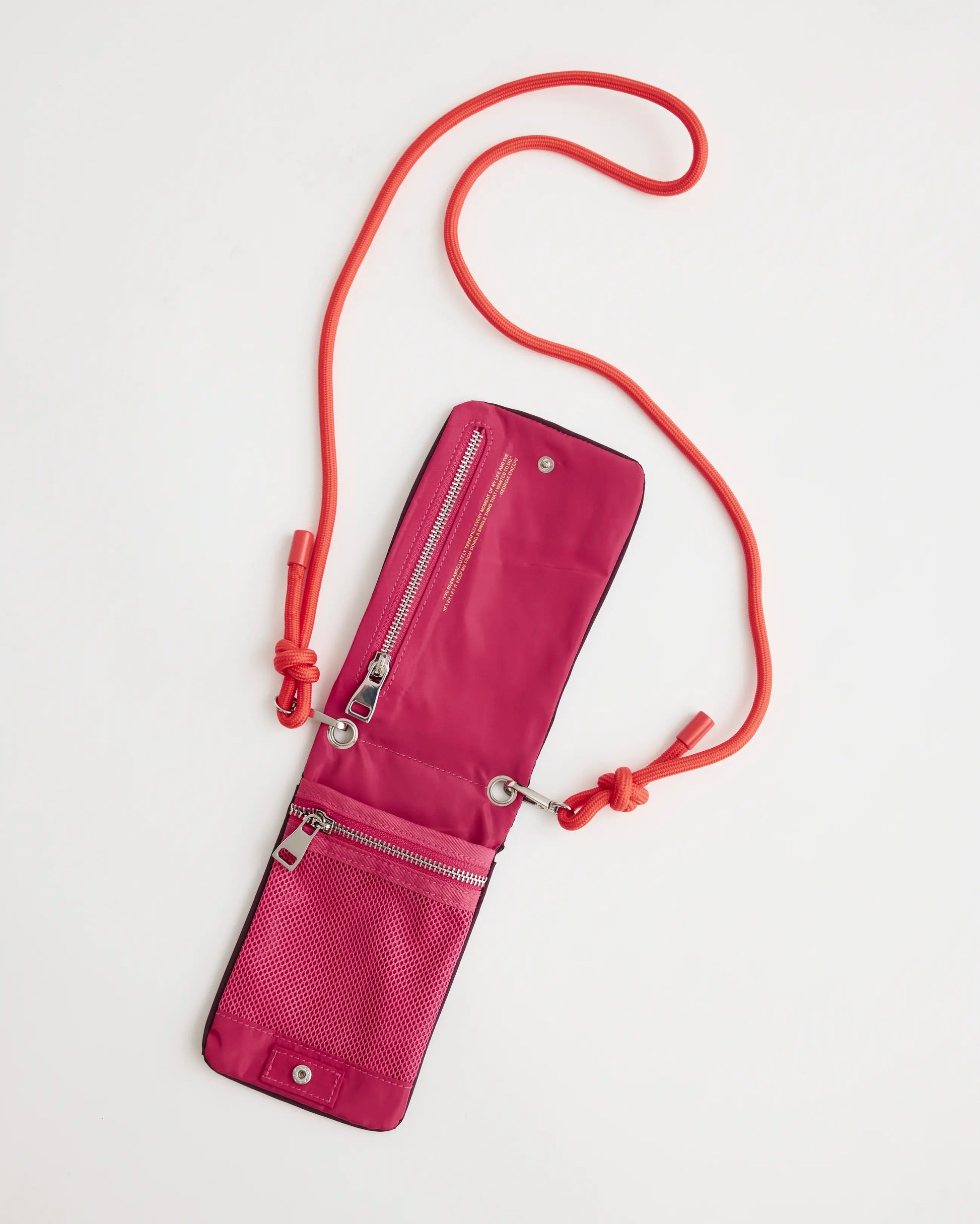 Open view of a purple phone pouch with bright pink interior that has multiple pockets and zips with an orange strap on a white background.