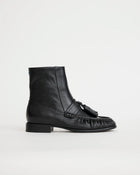 Black leather boot with tassel on a white background