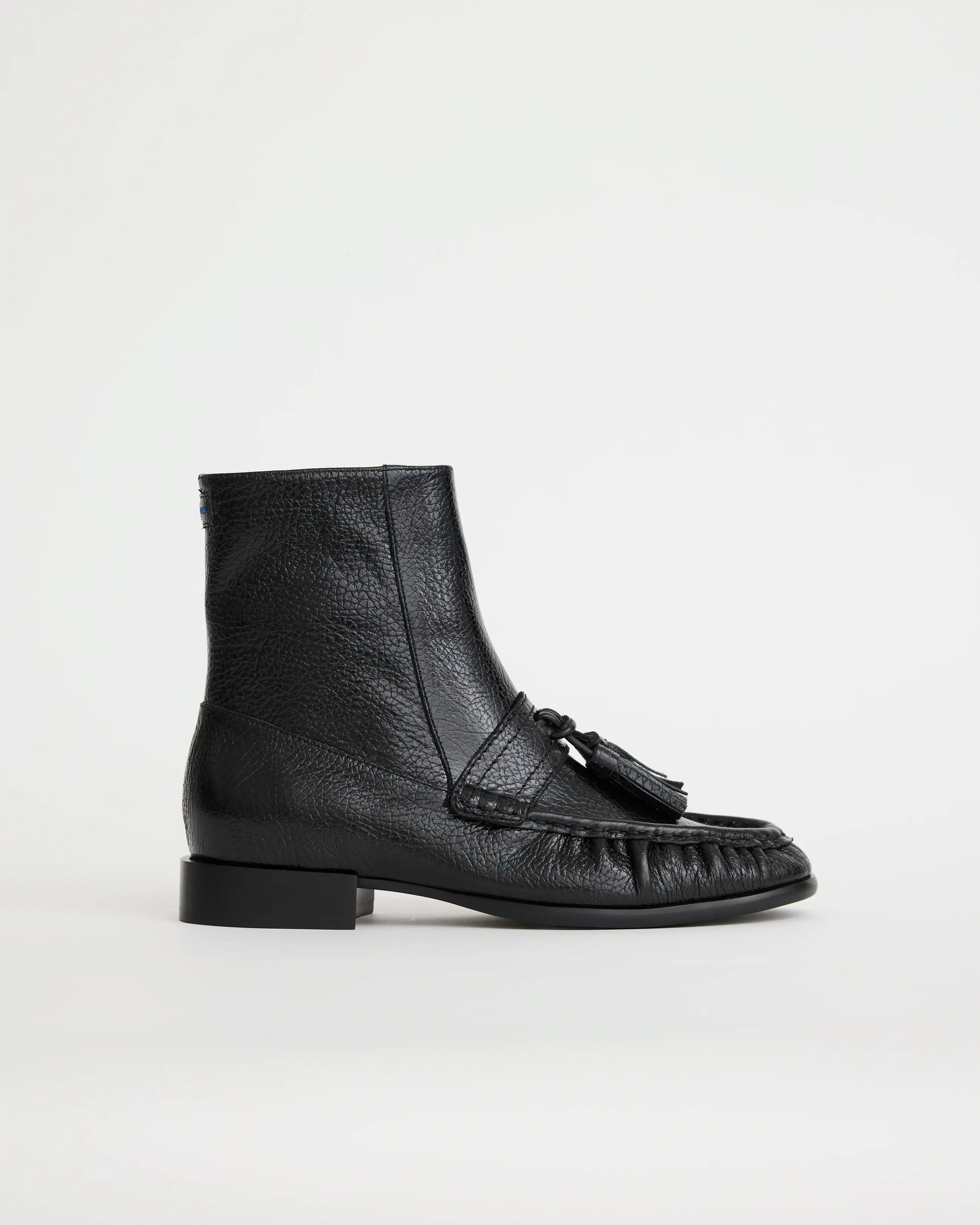 Black leather boot with tassel on a white background