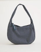 Navy and white polka dot handbag on a light gray background