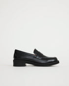 Black leather loafers on a light gray background