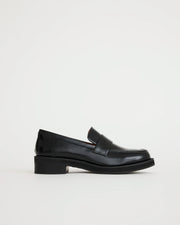 Black leather loafers on a light gray background