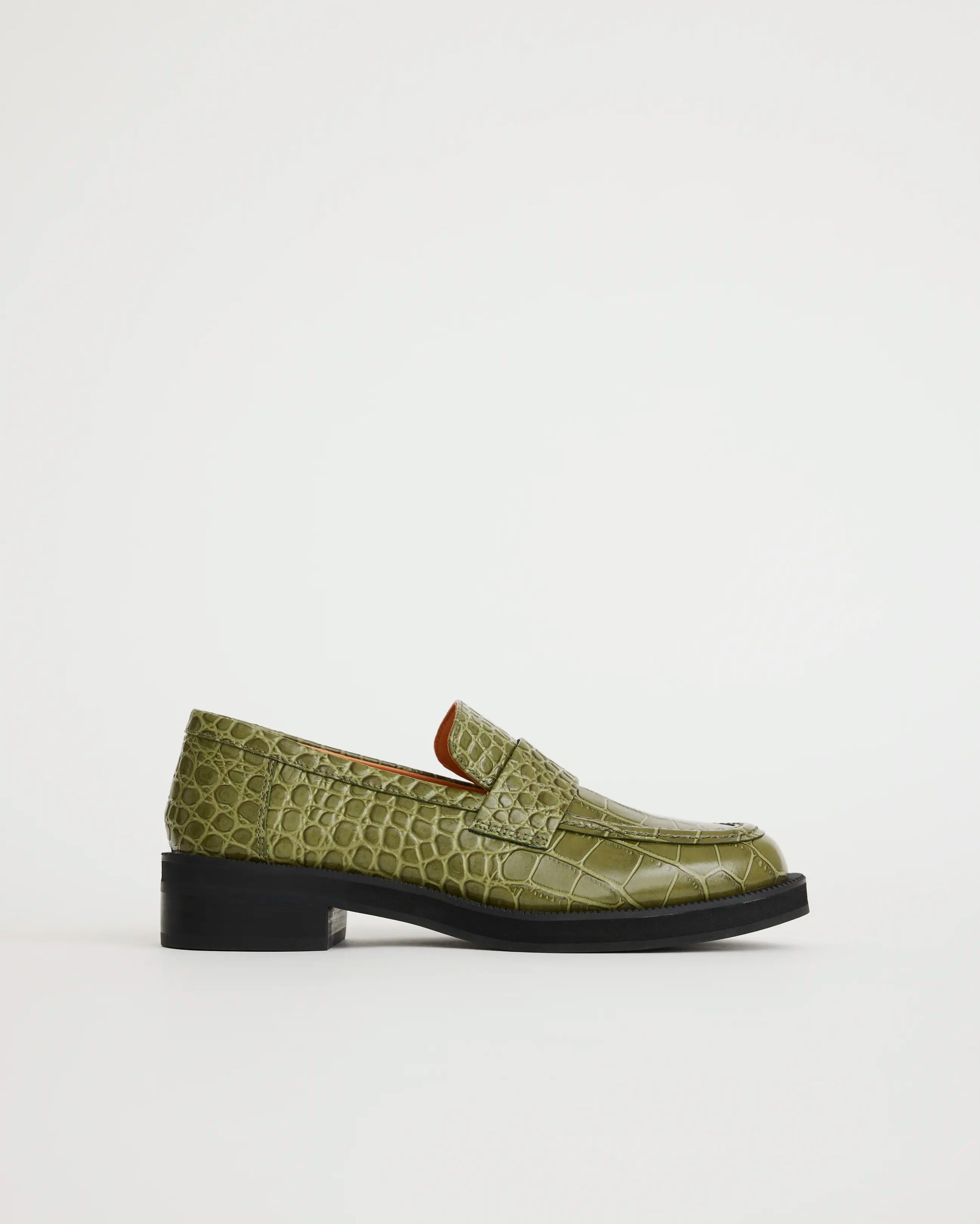 Green crocodile-textured leather loafer on a light gray background