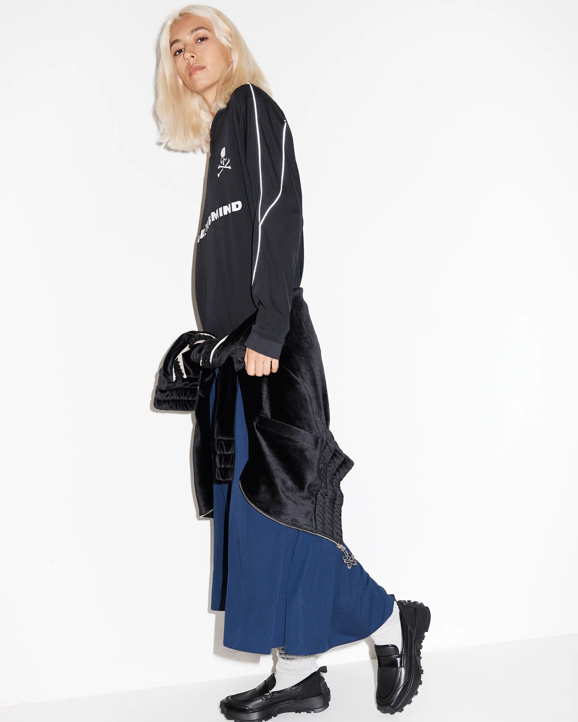 Person wearing a black and blue outfit with black leather chunky loafers