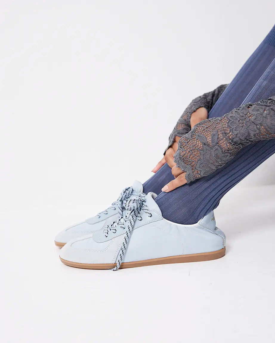 Light blue sneakers with brown soles on a white background
