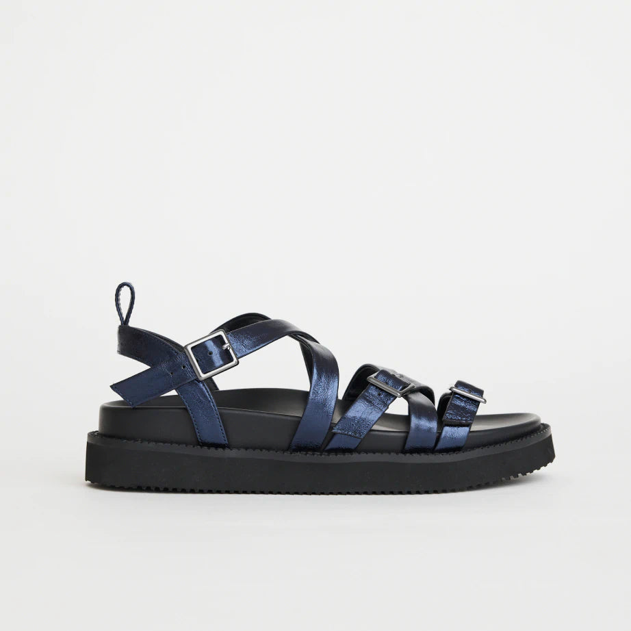 Women's strappy summer sandal in metallic navy leather with wedge sole and arch support.