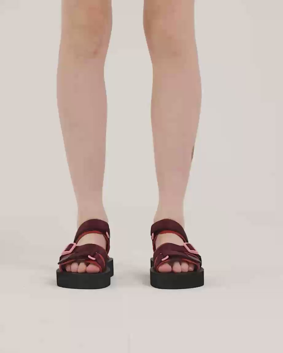 Load video: Person wearing cherry and mango athletic sandals with velcro straps and pink accents