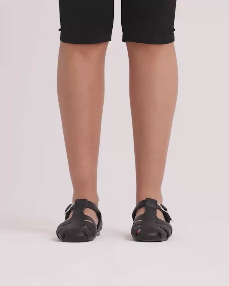 Person wearing black fisherman sandals against a white background.