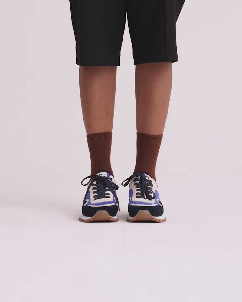 Blue sneaker on feet walking in a circle on white background