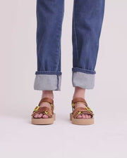 Person wearing denim and brown athletic sandals with velcro straps and yellow accents