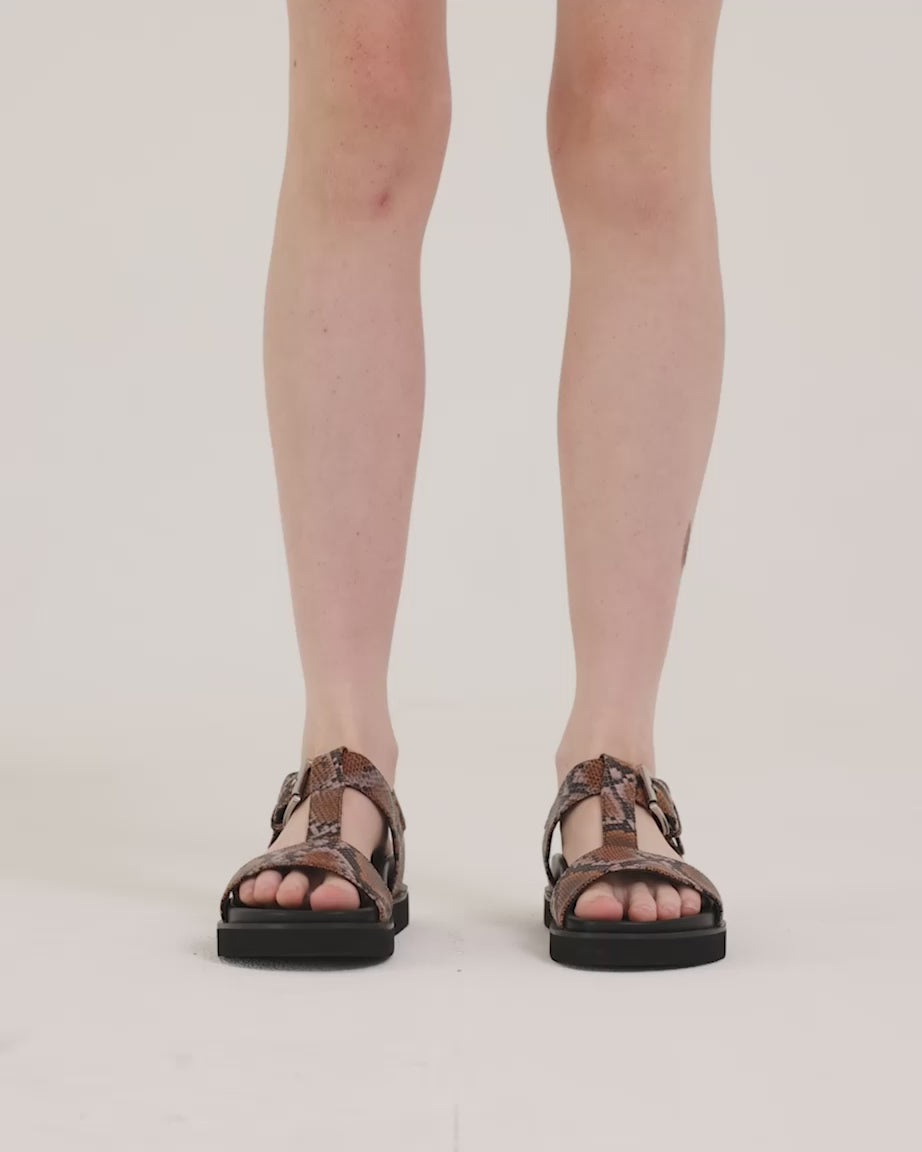 Load video: Person wearing arch support T-bar sandal with caramel snake print straps